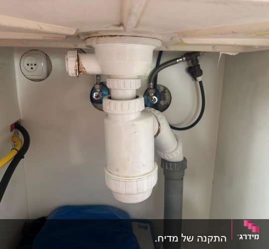 צנרת מתחת לכיור עם חיבורים וצינורות